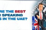 An animated character in a suit, wearing a headset, leans against a large English book with the Union Jack on its cover. The background features keywords like "skills," "communication," and "leadership." The bold text on the left reads, "What are the best public speaking courses in the UAE?" accompanied by Zabeel International Institute’s logo and website link, emphasizing educational options for enhancing public speaking skills in the UAE.