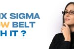 A thoughtful-looking woman with glasses, dressed in black, poses against a white background. Bold text on the left reads: “IS A SIX SIGMA YELLOW BELT WORTH IT?” with “YELLOW BELT” highlighted in yellow. Zabeel Institute logo is at the top left, and the website link https://zabeel-international.com/ appears at the bottom.
